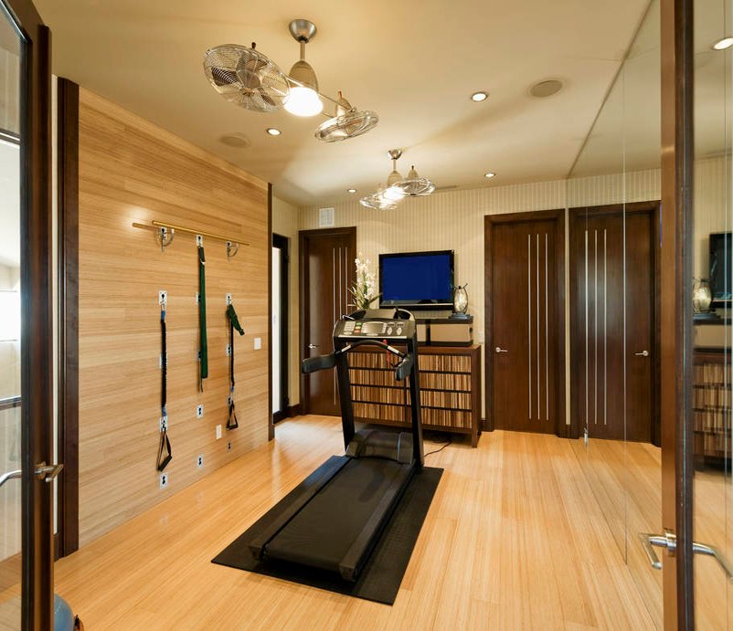 Home gym with treadmill, resistance bands, and mirrored wall