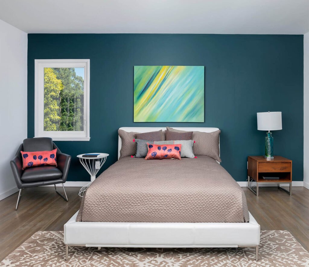 Modern bedroom with teal accent wall and vibrant artwork