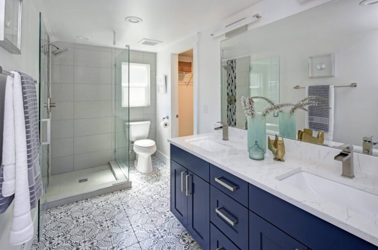 Modern bathroom with glass shower, blue vanity, and tile floor